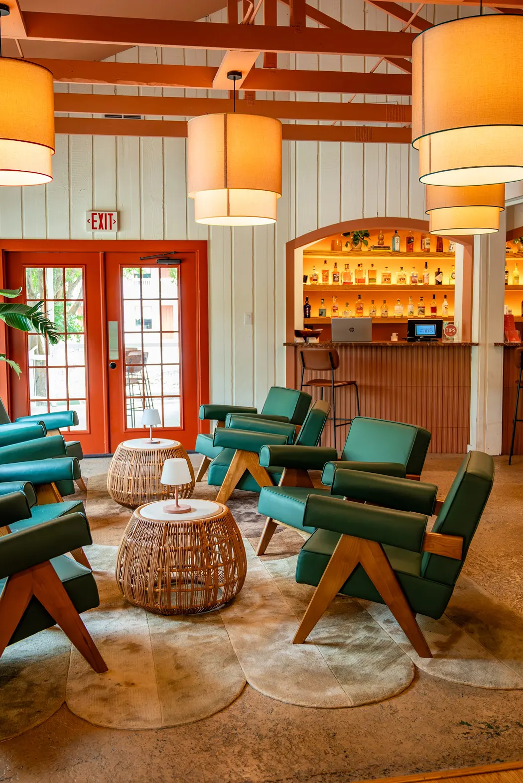 Bar room with green leather lounge chairs, drum pendants and a lit backbar, Hacienda del Rio