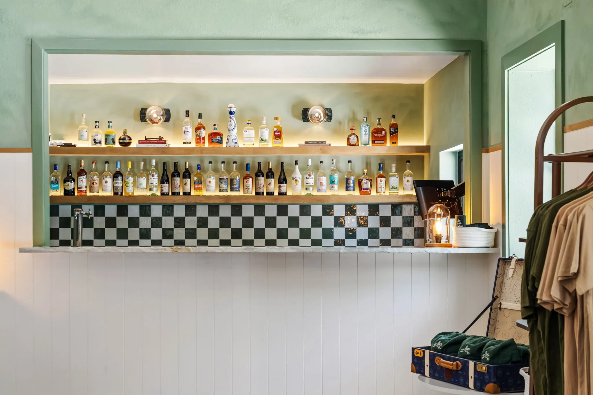 Bar with checkered tile and backlit bottle shelves, Petit Cowboy