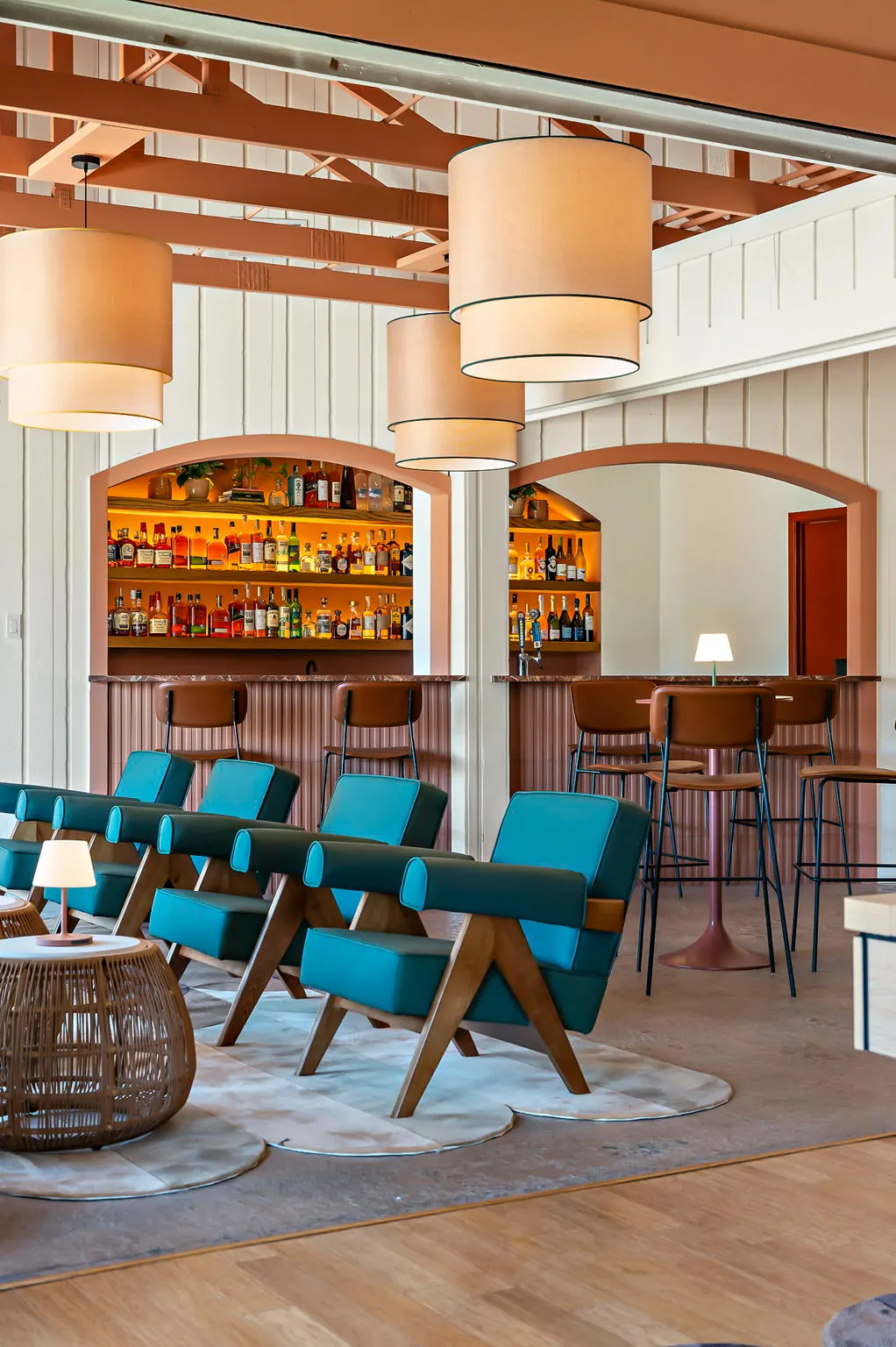 Bar with arched backbar, drum pendants and teal lounge chairs, Hacienda del Rio