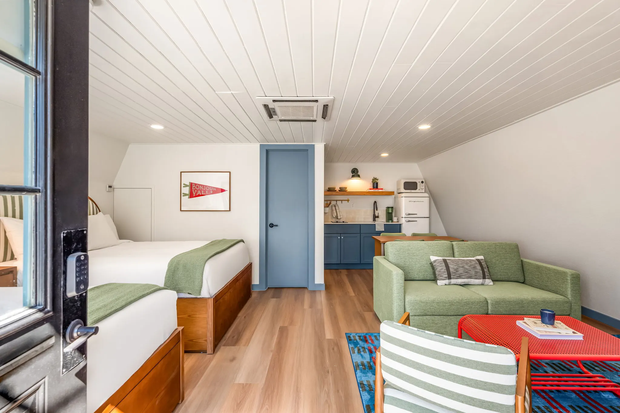 Suite from the door: two beds, green sofa and kitchenette, Petit Cowboy