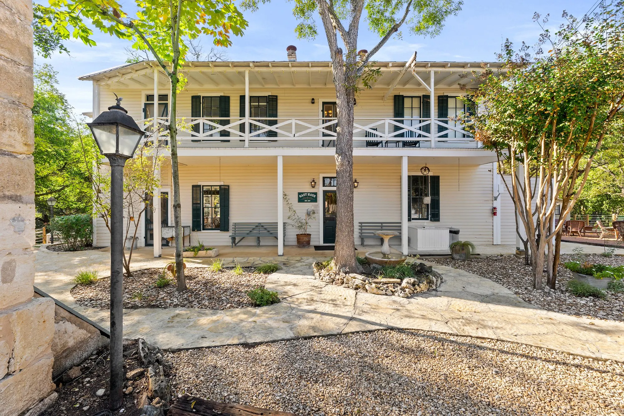 Two-storey Gast Haus with green shutters and a double porch over a gravel courtyard, The Meyer Hotel