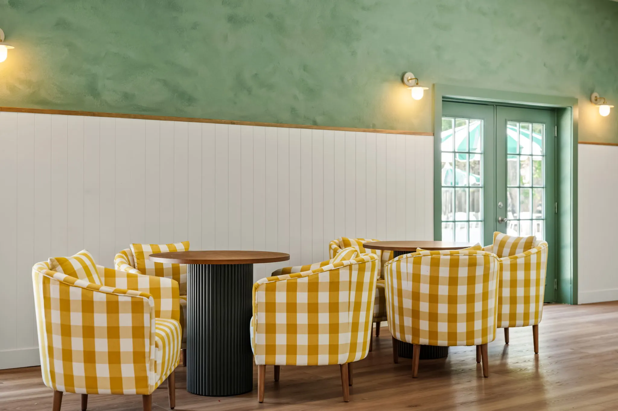 Café room with yellow gingham chairs, green plaster walls and doors to the umbrellas, Petit Cowboy