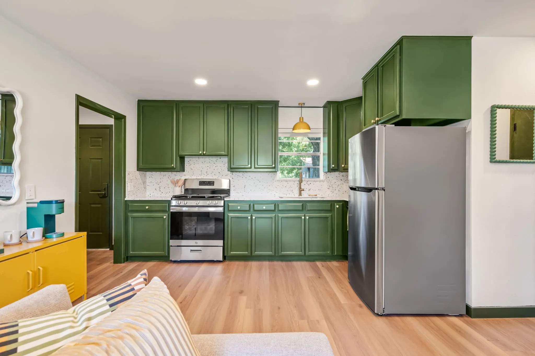 Cabin kitchen with green cabinets and terrazzo backsplash, Petit Cowboy
