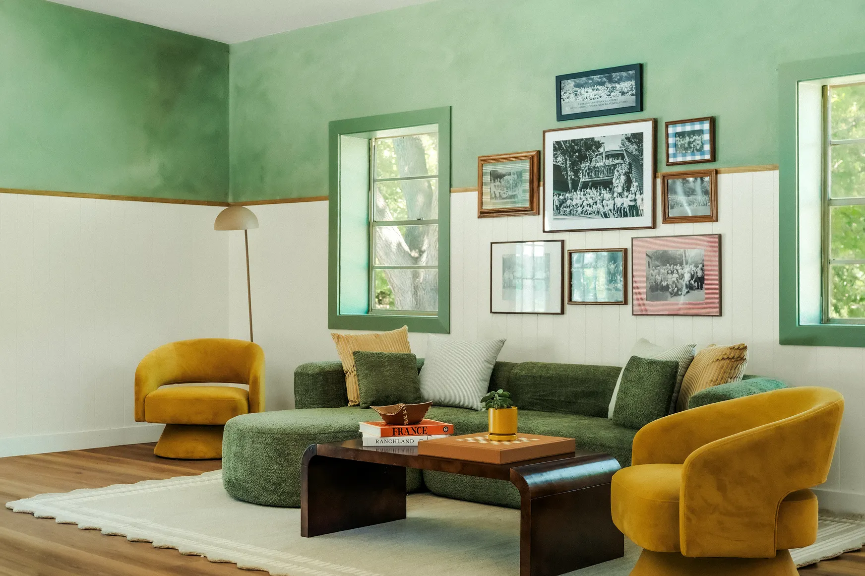 Green lounge with a mossy sectional, mustard swivel chairs and a wall of camp photographs, Petit Cowboy