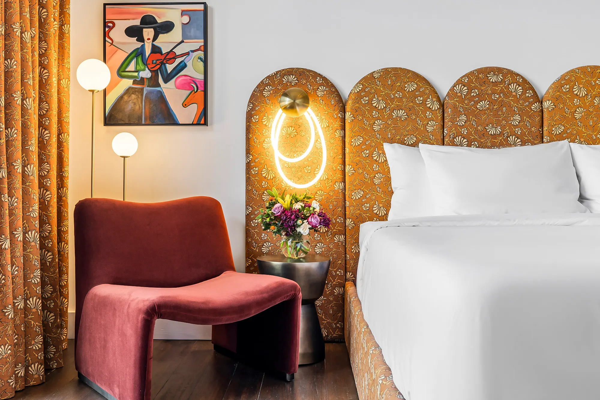 Headboard detail: brass sconce, block-print fabric, velvet chair, Gruene River Inn