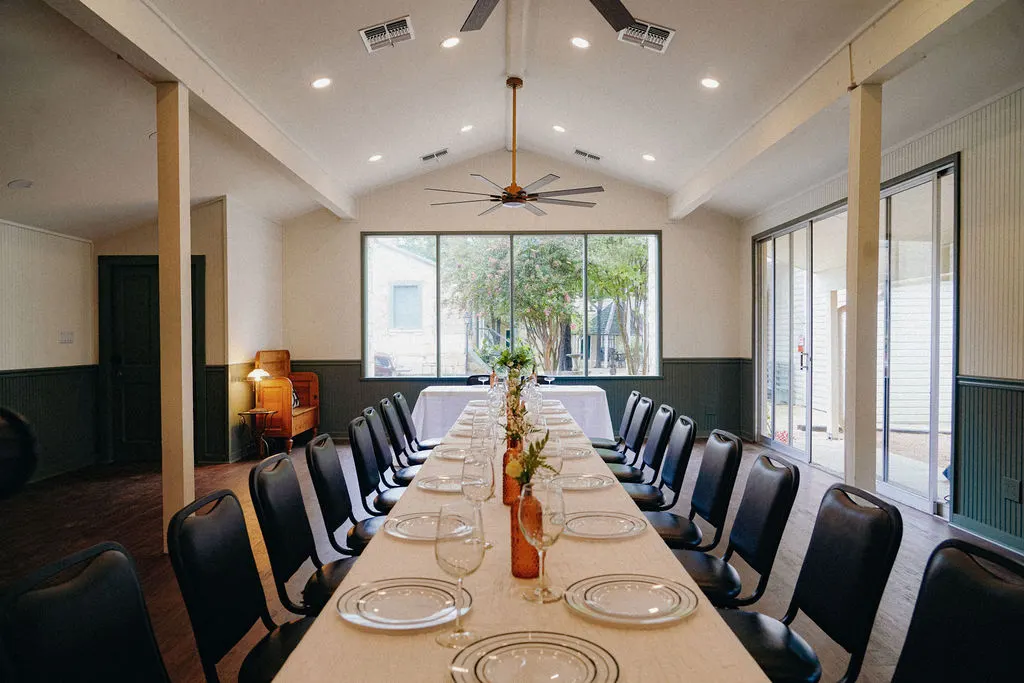Vaulted event room set with one long table, green wainscot and glass doors onto the porch, The Meyer Hotel