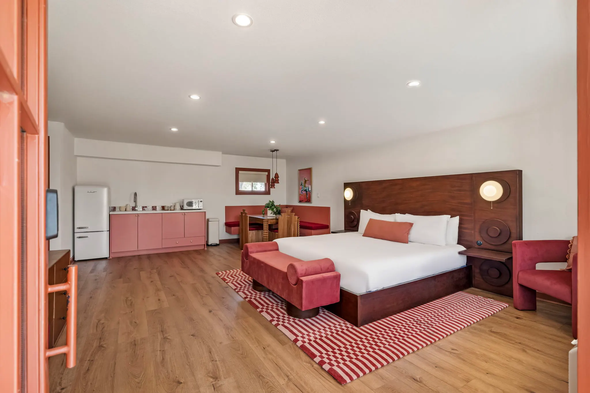 Pink studio suite with a carved walnut headboard and kitchenette, Hacienda del Rio