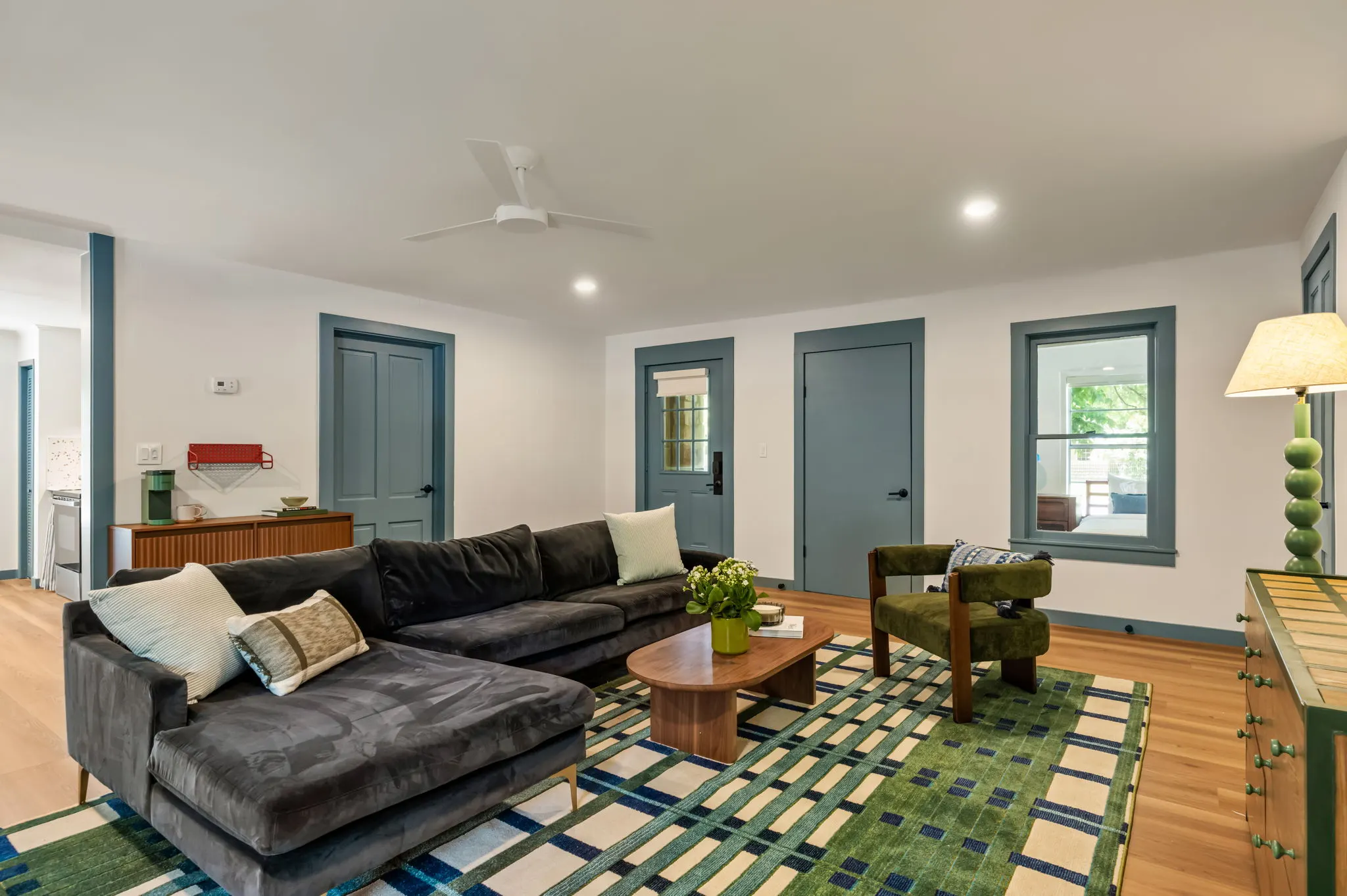 Cabin living room with a plaid rug and blue-trimmed doors, Petit Cowboy