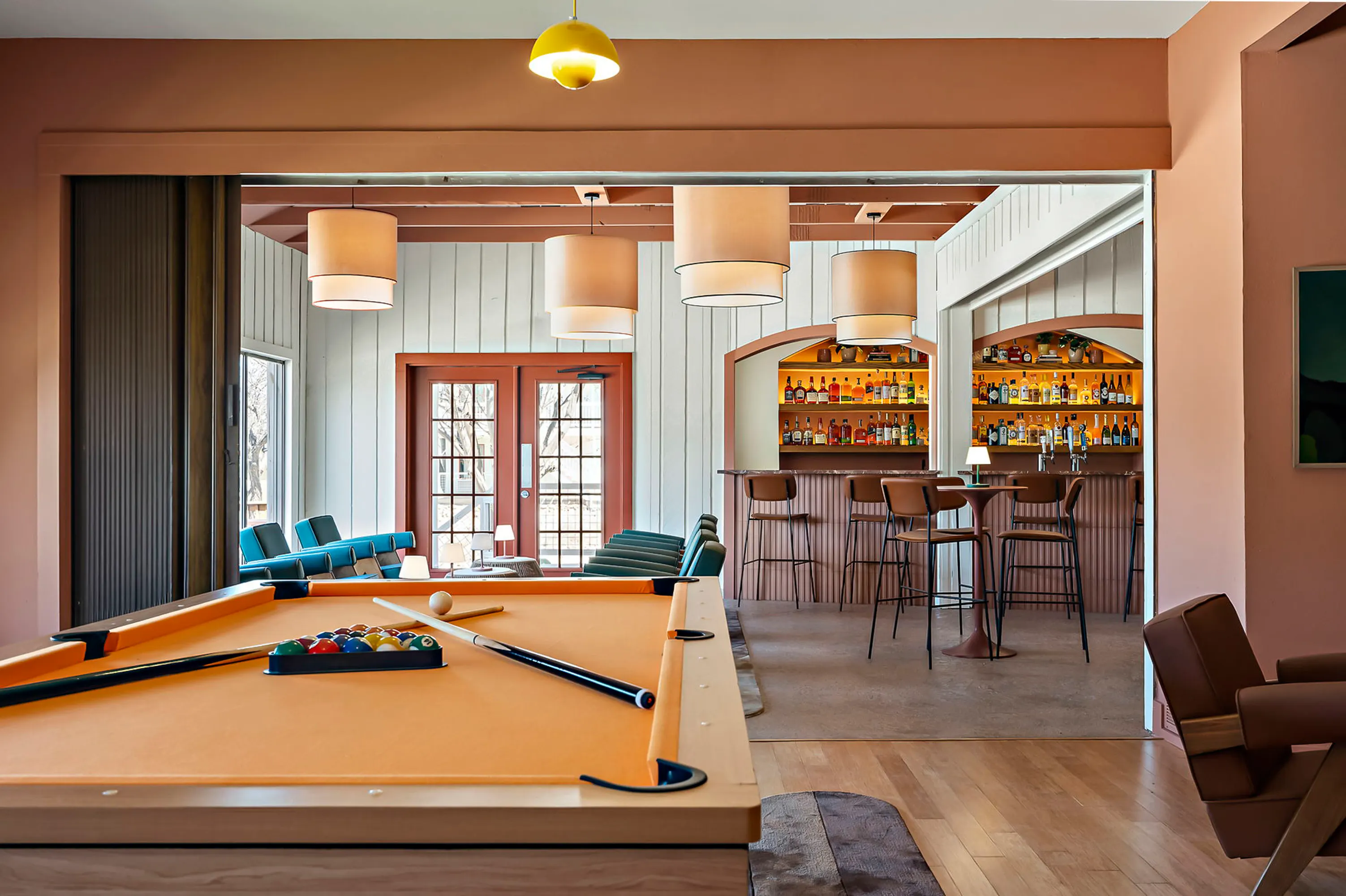Game room with an orange pool table, drum pendants and the arched backbar beyond, Hacienda del Rio