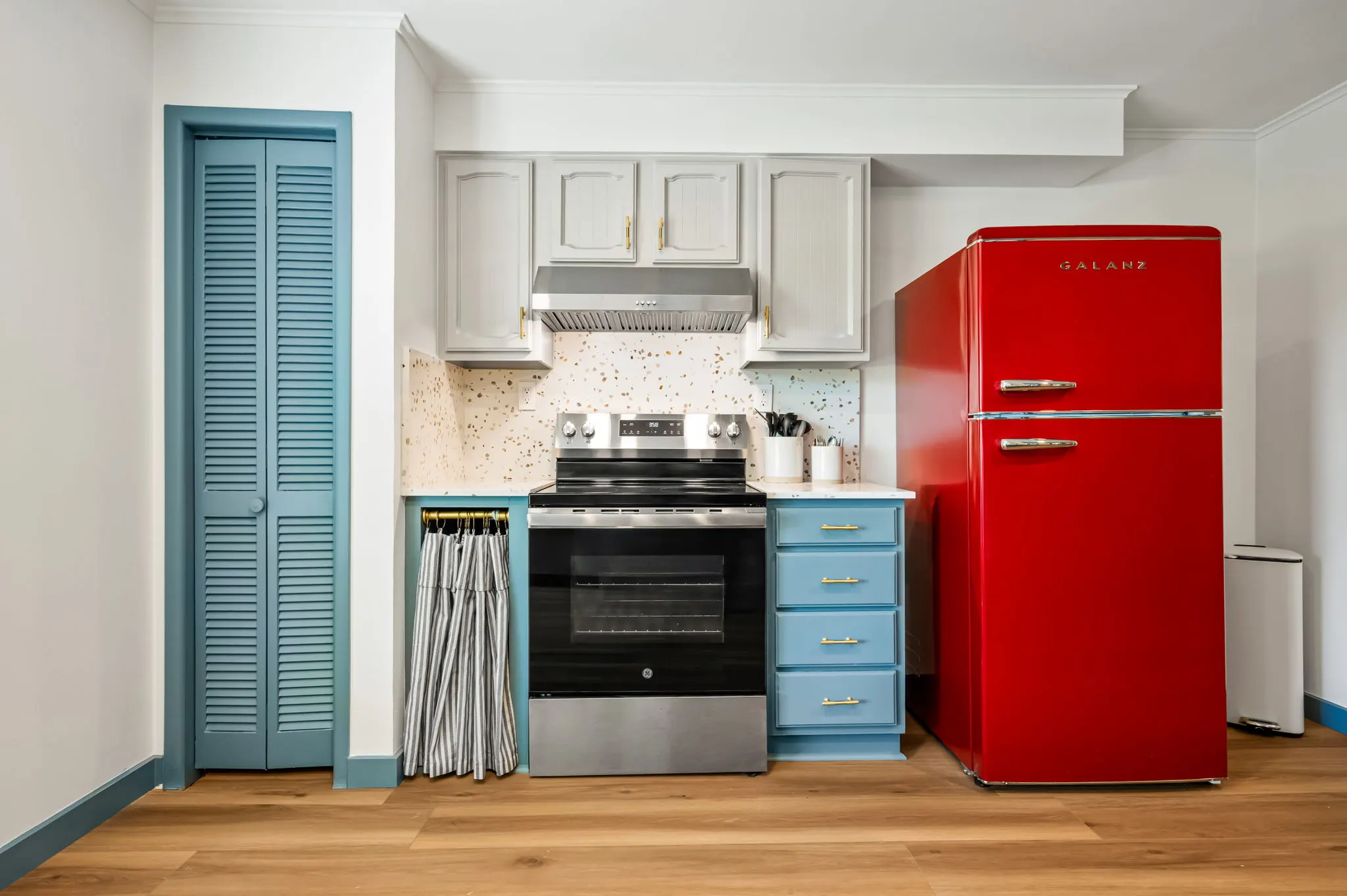 Kitchenette with blue cabinets and a red retro refrigerator, Petit Cowboy