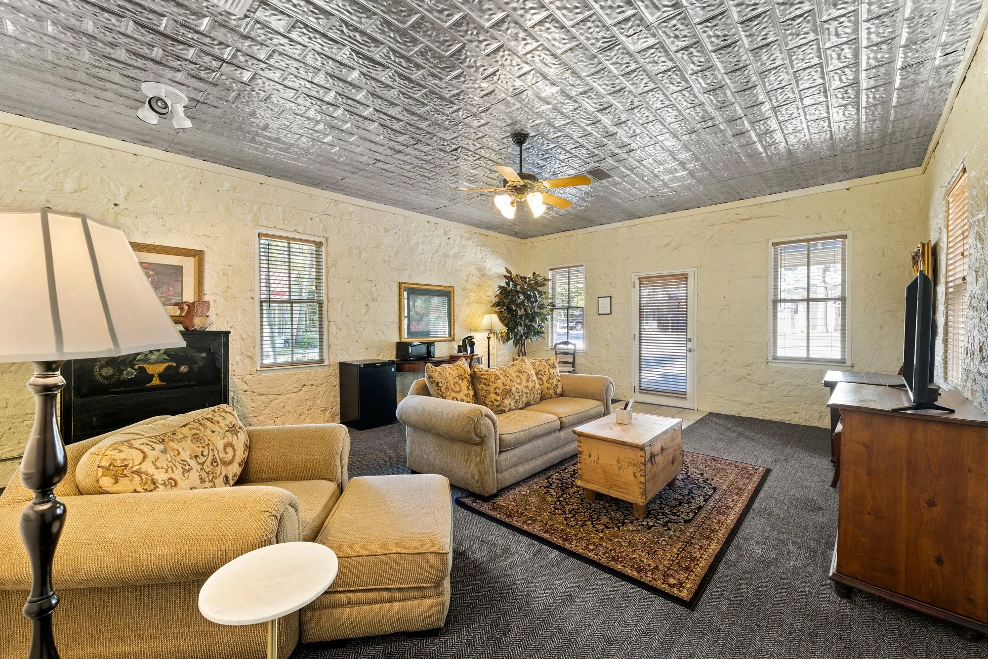Stone-walled lounge under a pressed-tin ceiling, The Meyer Hotel