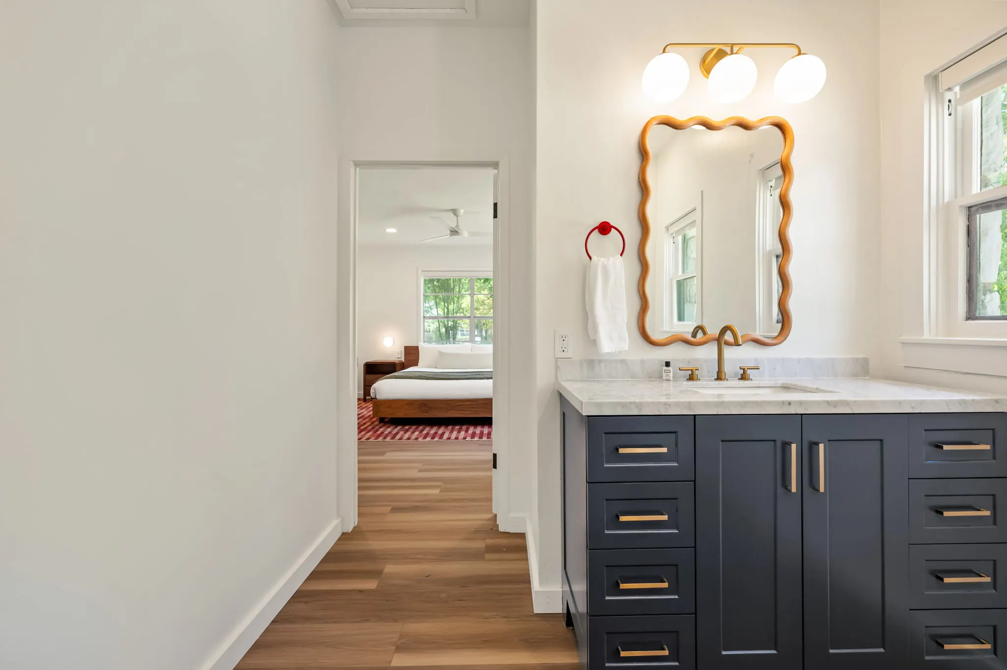 Marble vanity with a wavy mirror, bedroom beyond, Petit Cowboy