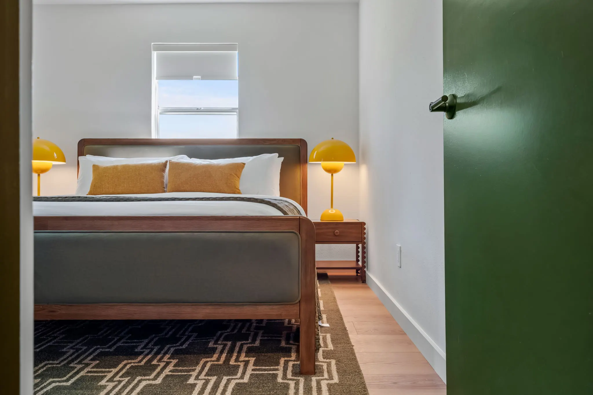 Bedroom with a walnut bed and yellow bedside lamps, Petit Cowboy